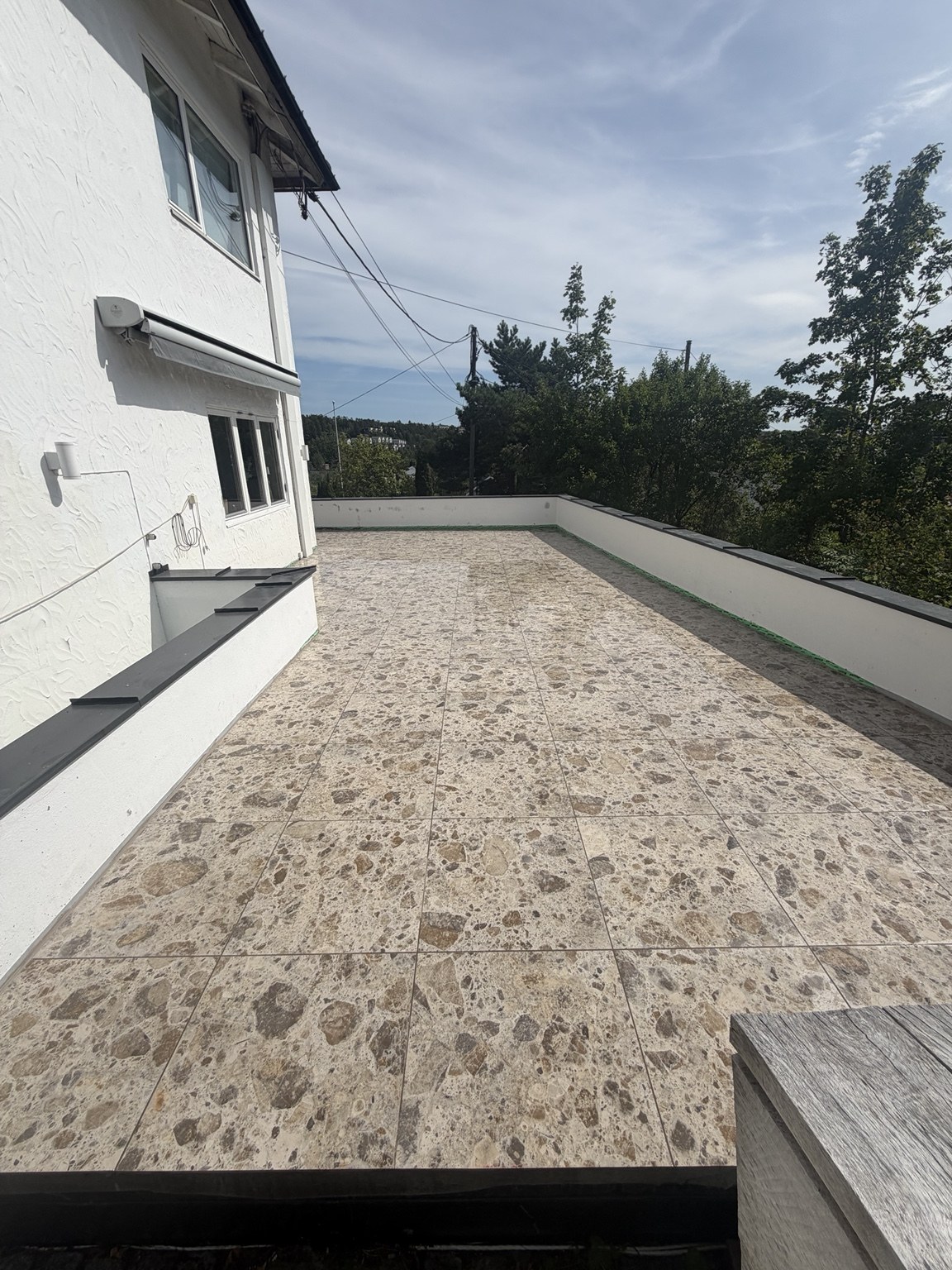 Flislagt terrasse med store heller og åpen utsikt